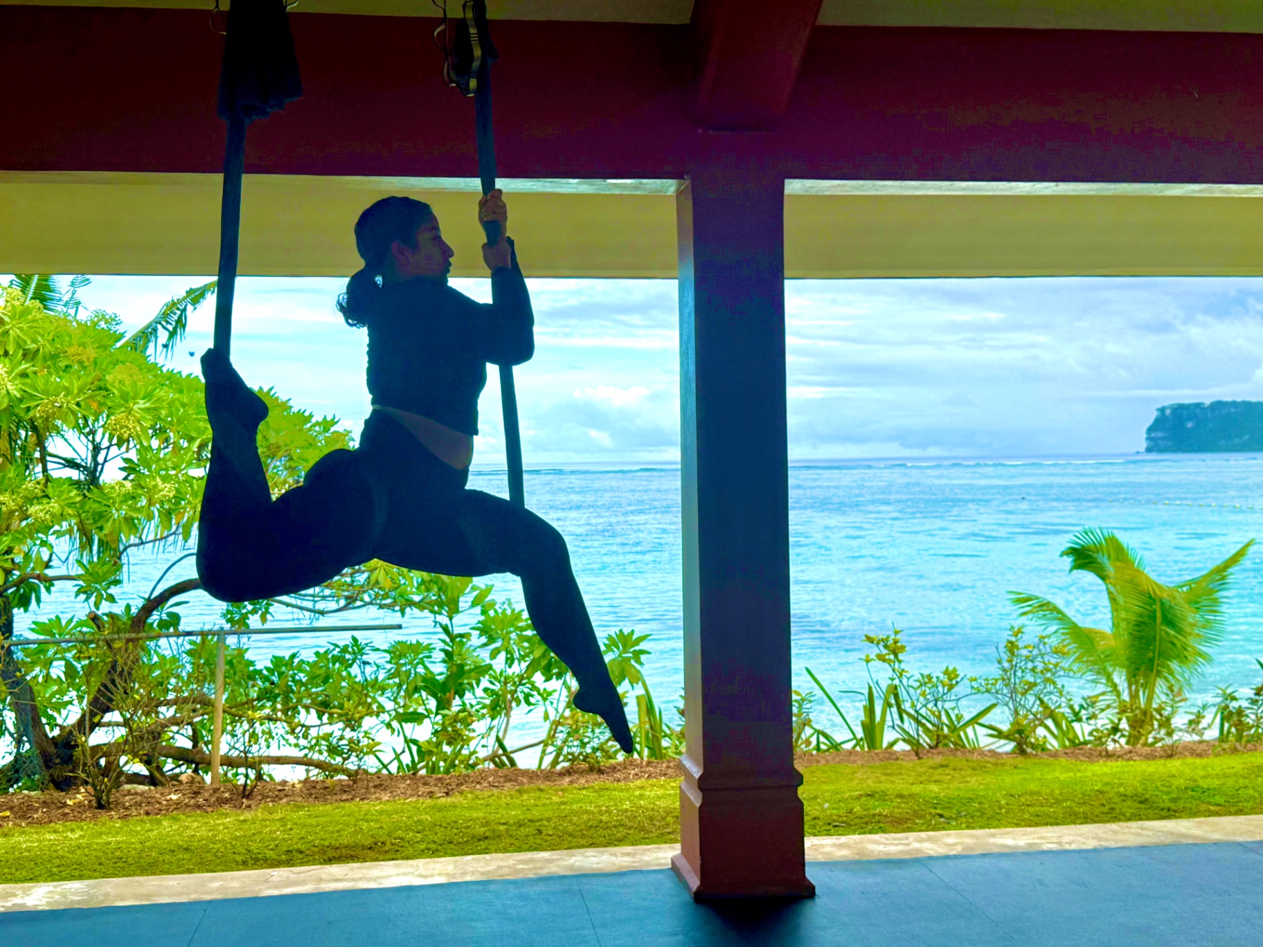 Silhouette climbing silk with ocean horizon